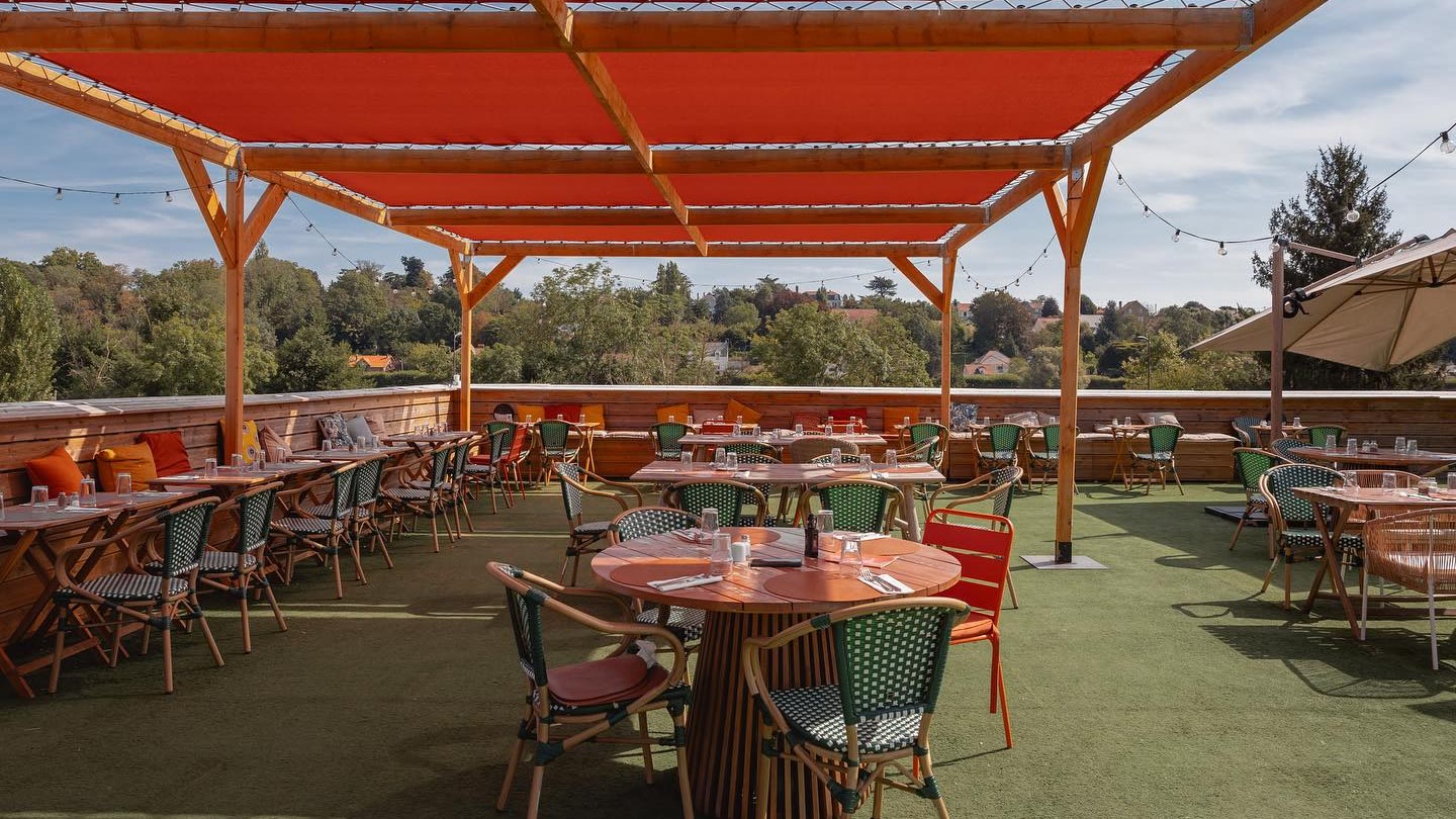 Le rooftop de La Piscine, tables dressées sous les voiles terracotta